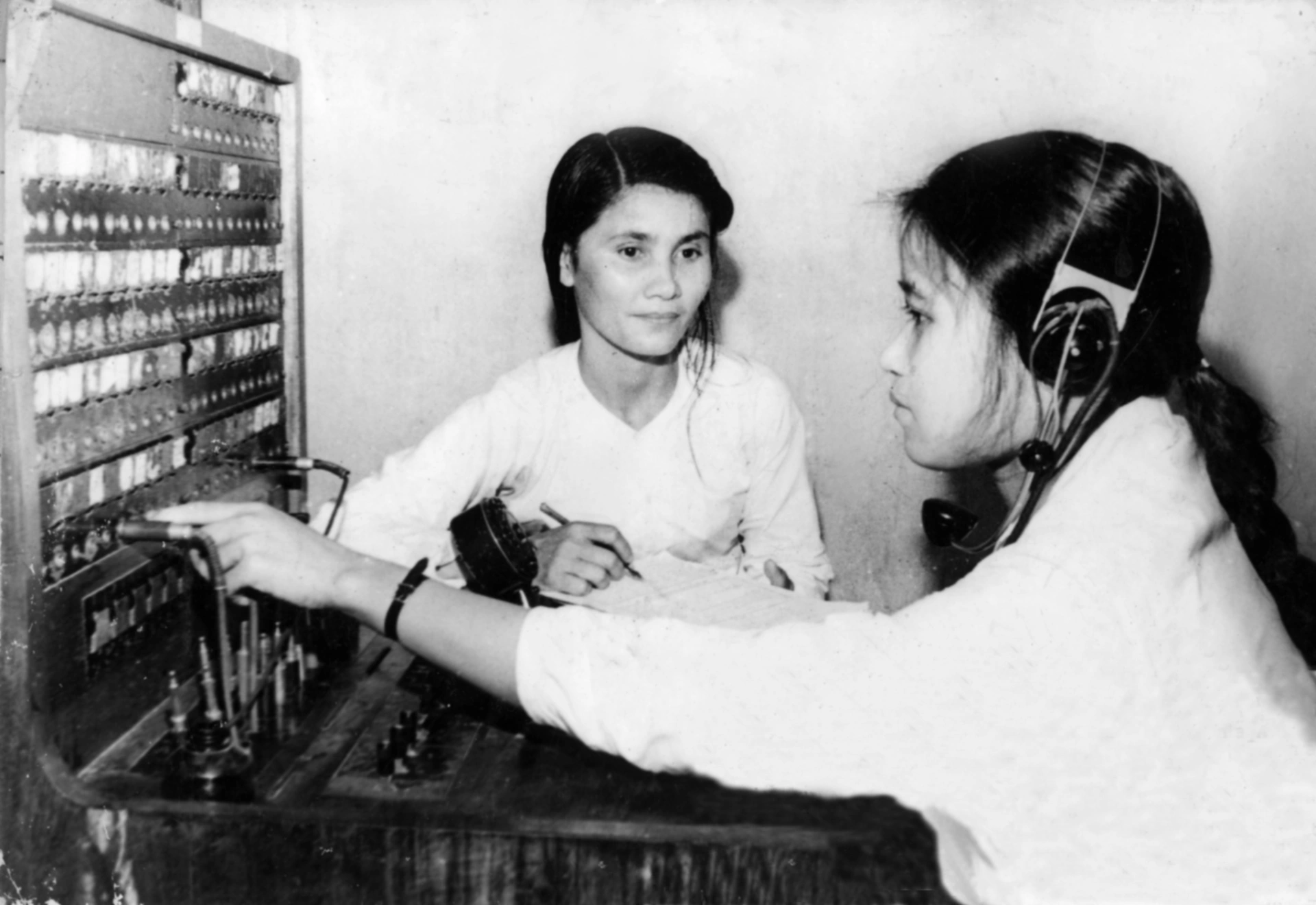 ĐTV Lại Thị Thơ và Hoàng Thị Ríu- BĐ Đông Anh bám máy tiếp dây thông tin phục vụ chỉ huy chiến đấu. (30.06.1966)